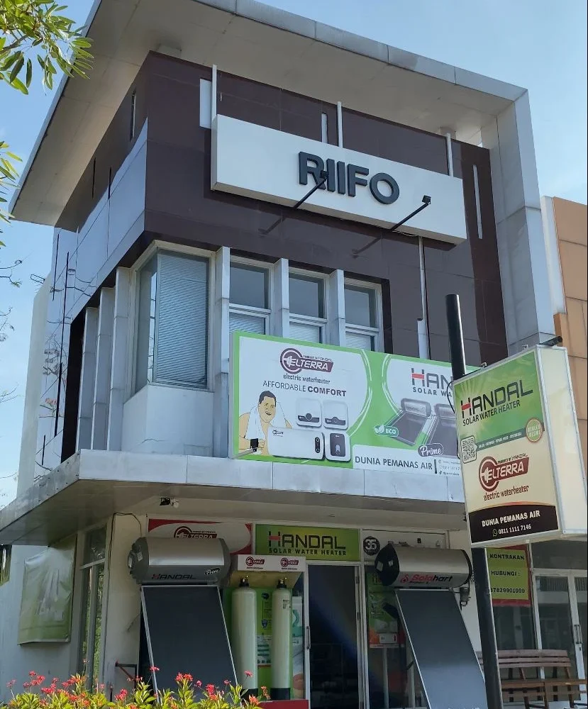 Gedung dua lantai dengan papan nama "Riffo" dan berbagai produk pemanas air merek Handal dan Elterra.