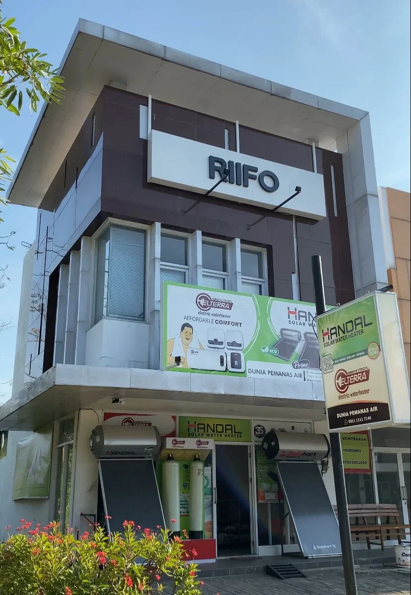 Gedung dua lantai dengan papan nama "Riffo" dan berbagai produk pemanas air merek Handal dan Elterra.